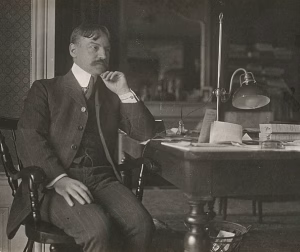 Photographie de Julien Benda en noir et blanc, vers 1900-1910, assis à son bureau.